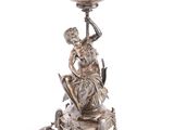 an antique silver plate topped with a statue of a woman on a horse