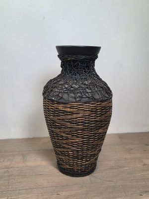 a black and brown vase sitting on a wooden table
