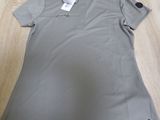 the polo shirt is sitting on a wooden table with a tag on it