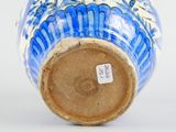 a blue and white vase sitting on a white surface