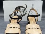 une paire de sandales pour femme, noires et beiges, avec des lanières noires