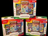 three boxes of pokemon cards are shown on a black background