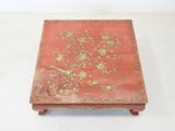 a small red table with a floral design on it