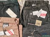 several pairs of men ' s jeans with price tags on them