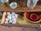 a wooden table with a bowl of rocks and a bowl of water