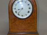 une petite horloge en bois avec des chiffres romains