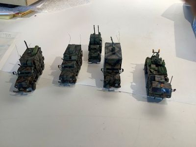 several military vehicles are lined up on a white table