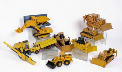 de nombreux engins de chantier miniatures posés sur une surface blanche