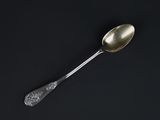 a silver spoon with a spoon handle on a black surface