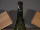 a bottle of wine sitting on a table next to a block of wood