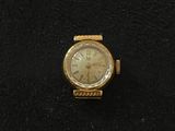 an image of a gold watch with roman numerals on the face