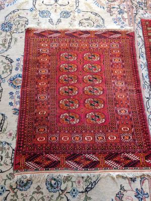 two rugs are laid out on a bed with a cat sleeping on the bed