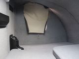 a bed in the back of a car with a mirror above it