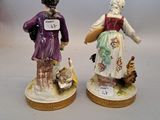 two figurines of a woman and a man standing next to each other