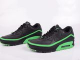 une paire de baskets noires et vertes sur fond blanc