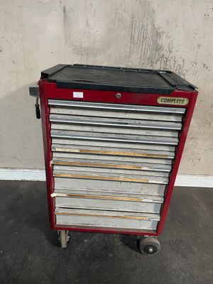 a red and black tool cabinet sitting on top of a cement floor