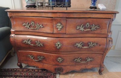 une commode en bois sur laquelle est posé un vase bleu