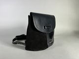 black leather backpack on white surface with white background