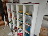 a white bookcase filled with lots of books