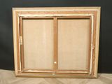 an empty picture frame sitting on top of a wooden floor
