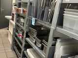many shelves in the kitchen with dishes and pans on them