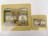 two coasters with a picture of a store front and a bicycle outside
