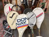 many tennis rackets that are sitting on the floor