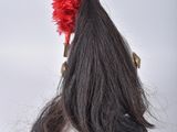a long black hair with a red flower on top of it