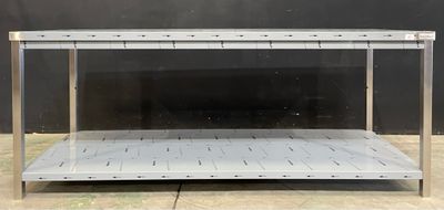une table en métal avec une étagère en dessous, posée sur un sol carrelé