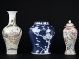 trois vases sont alignés sur une surface noire, sur fond noir
