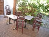 many chairs and tables on the deck of this house