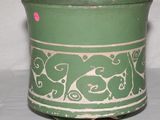 un vase vert et blanc sur lequel est collé un autocollant rose