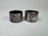 pair of antique silver napkins with designs on them on a white surface