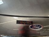 the front end of a silver car with a sticker on it ' s hood