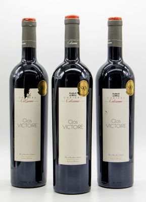 three bottles of red wine sitting next to each other on a white surface