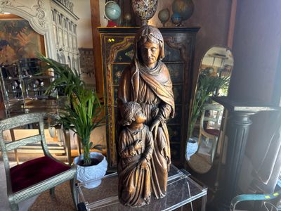 a statue of a woman holding a child in a living room