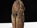 a wooden sculpture of a man on a white table