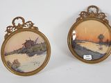 two framed pictures of a house and a river in a gold frame
