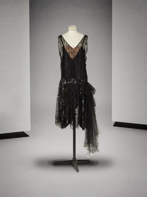 une robe noire posée sur un mannequin dans une pièce blanche