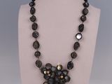 Le collier est composé de perles de verre et d'une perle noire