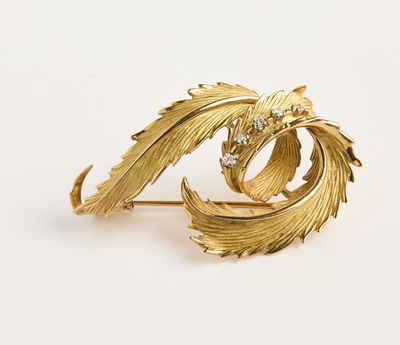 un gros plan sur une broche dorée ornée de feuilles