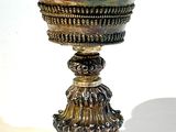 une coupe en argent posée sur un socle, sur fond blanc