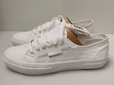 white sneakers with bows on the side of them on a white surface