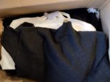 a box full of clothes that is sitting on the floor