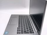 a silver laptop with a black keyboard on a white surface