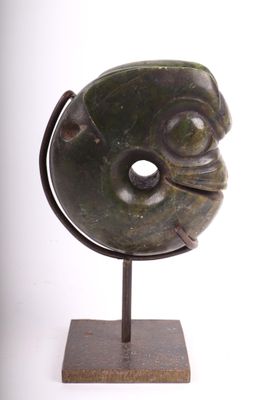 sculpture représentant un visage, posée sur un socle, sur fond blanc