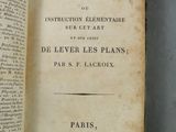 un vieux livre ouvert, dévoilant une page de texte sur une surface grise