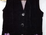 black velvet vest with purple flowers on it and a wooden hanger on a white background