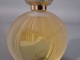 an image of a bottle of perfume sitting on top of a table