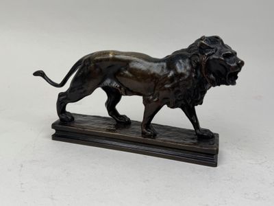 statue en bronze représentant un lion, posée sur un socle en marbre, sur fond blanc